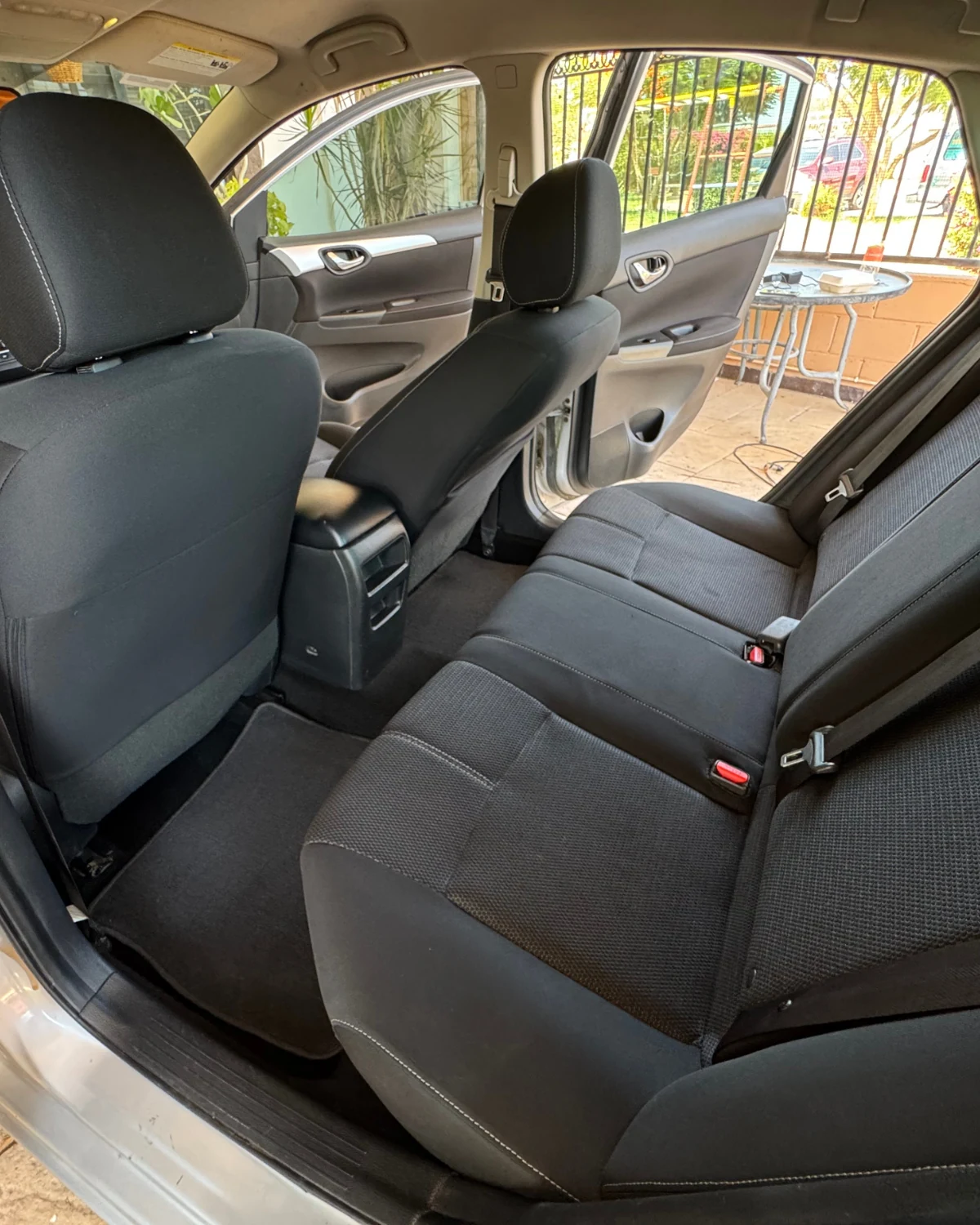 Asientos traseros de tela de un Nissan Sentra limpios después del Interior Detallado