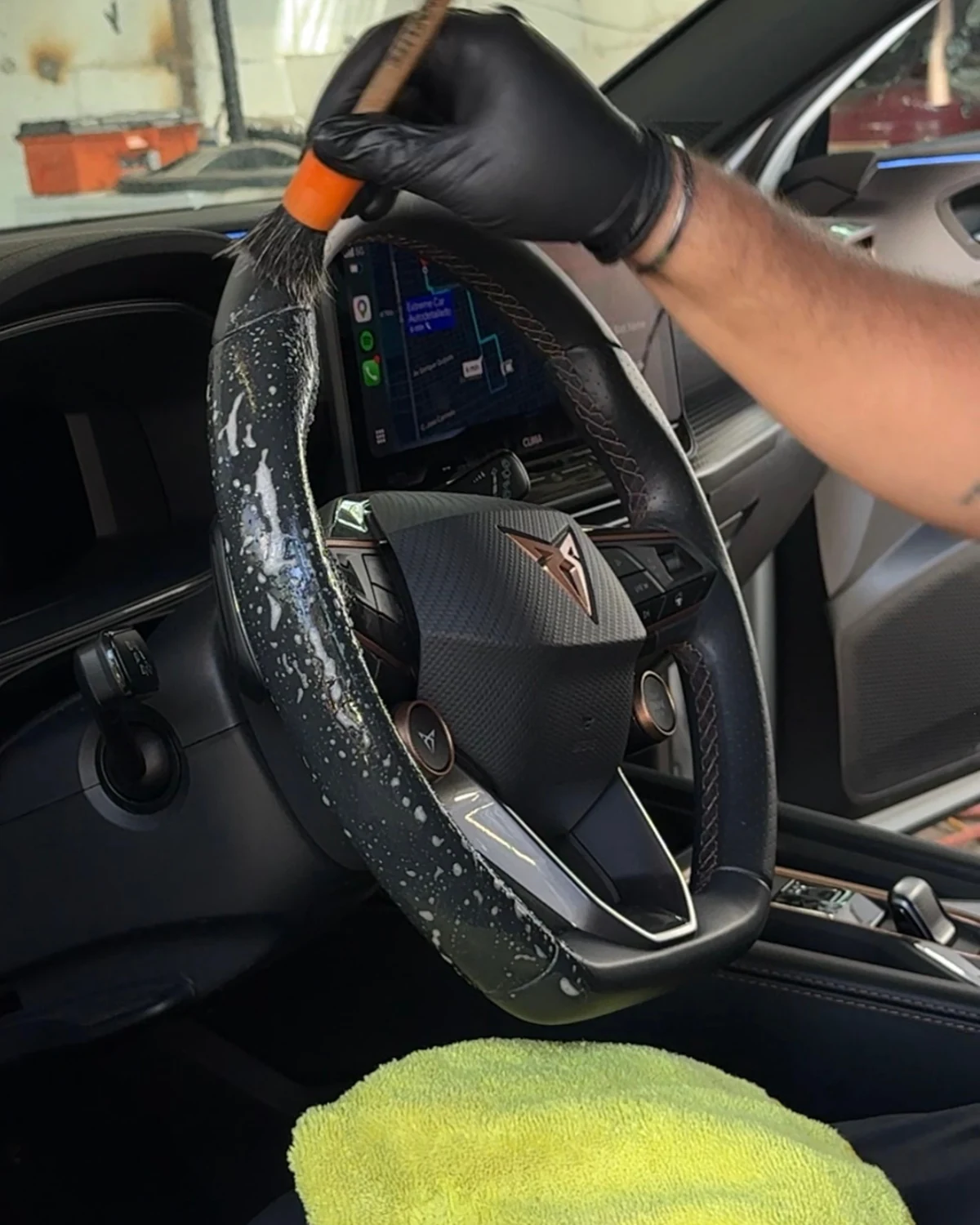 Limpieza del volante de un Cupra con brocha y producto para piel
