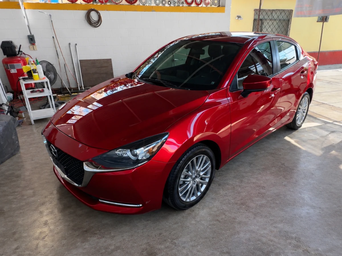 Mazda 2 rojo con la pintura brillante después del Combo Completo en el taller de Orange